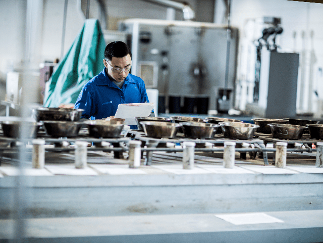 Man in laboratory examining soil boring samples in a row of metal containers